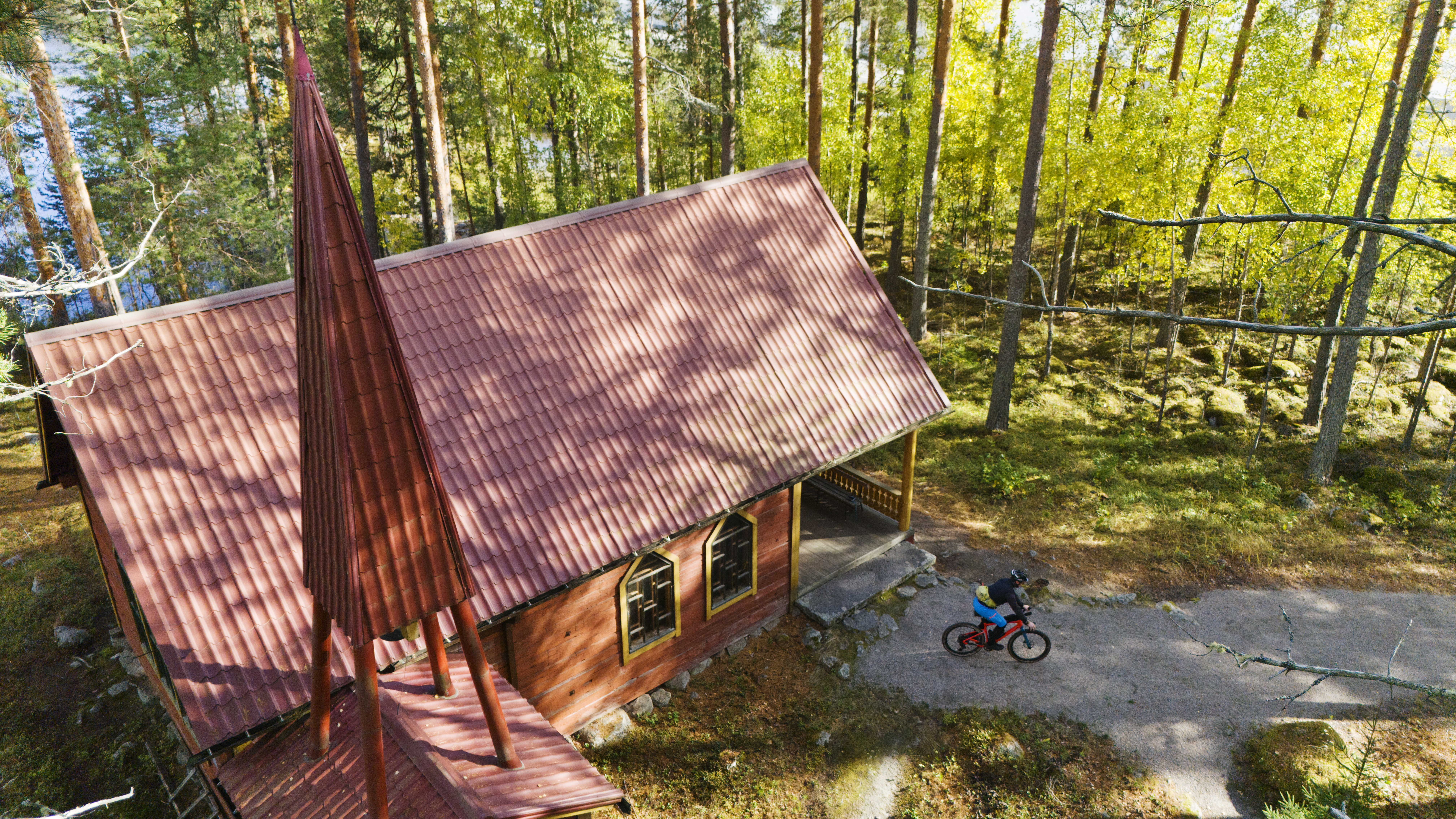 Summer church seen from above, a cyclist setting off.