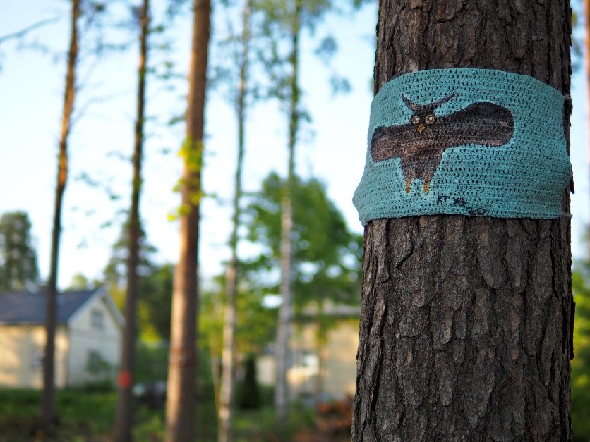 Bird-themed yarn graffiti on a tree