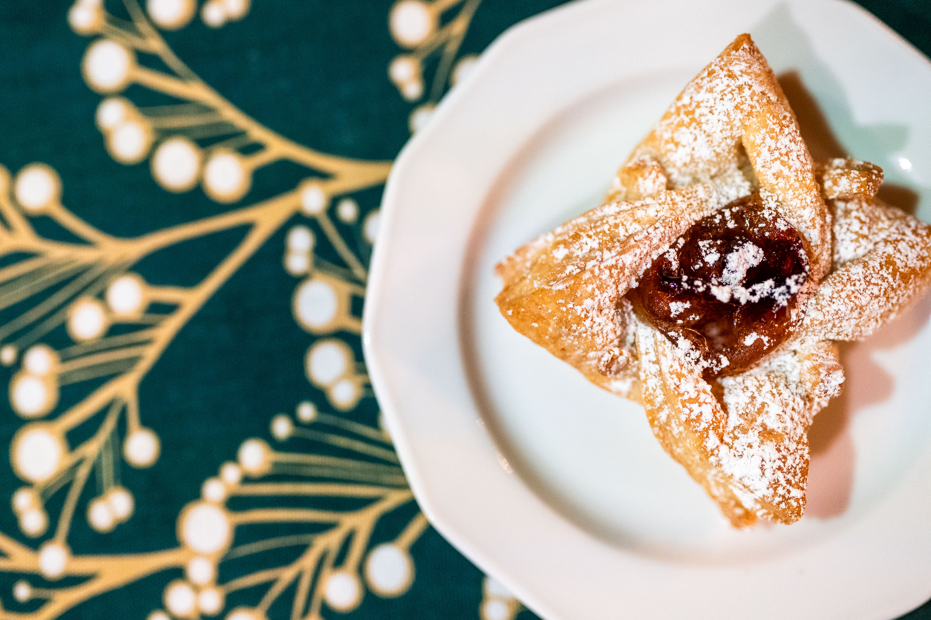 A Christmas star pastry on a plate on a tablecloth.