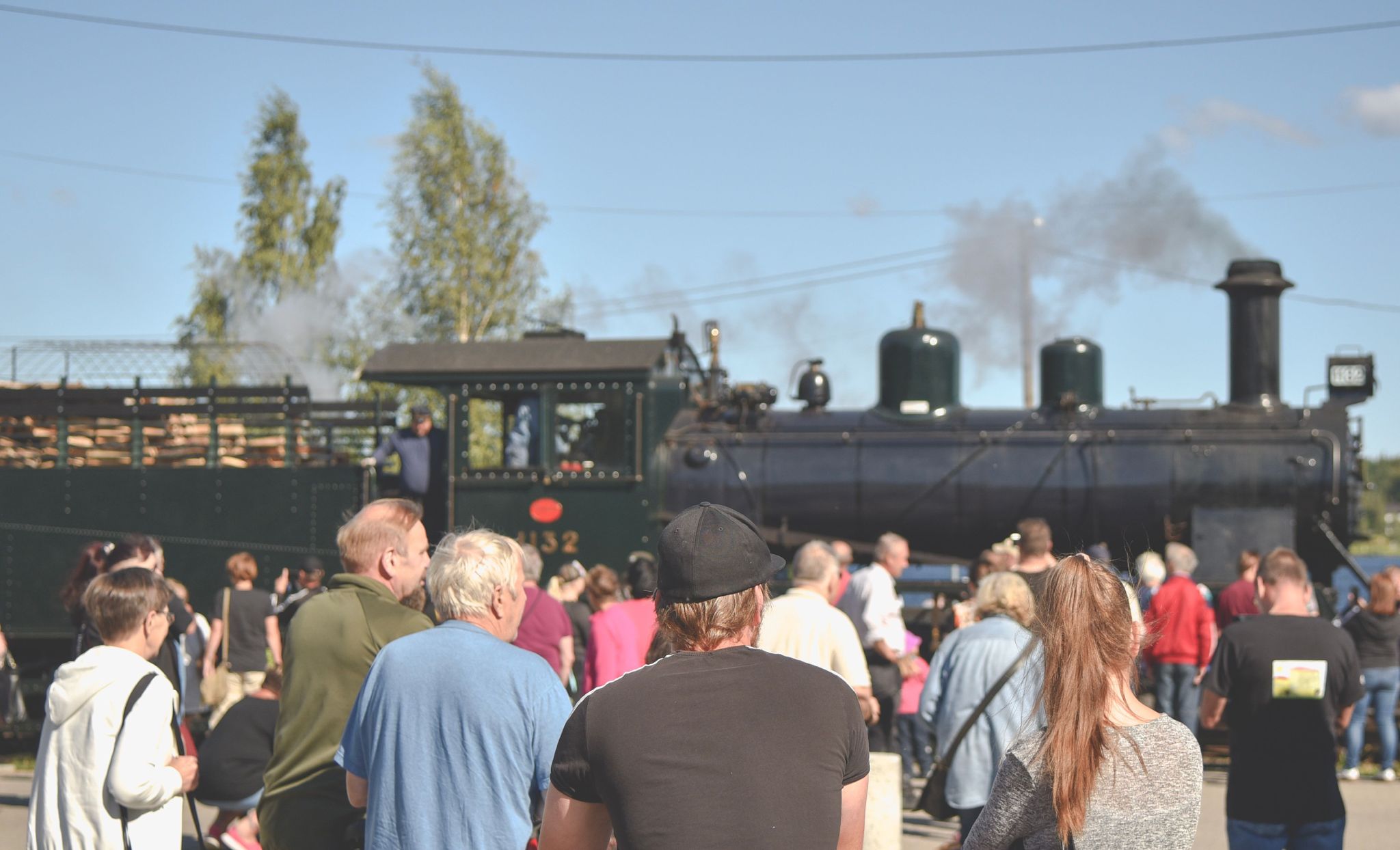A steam train and a crowd.
