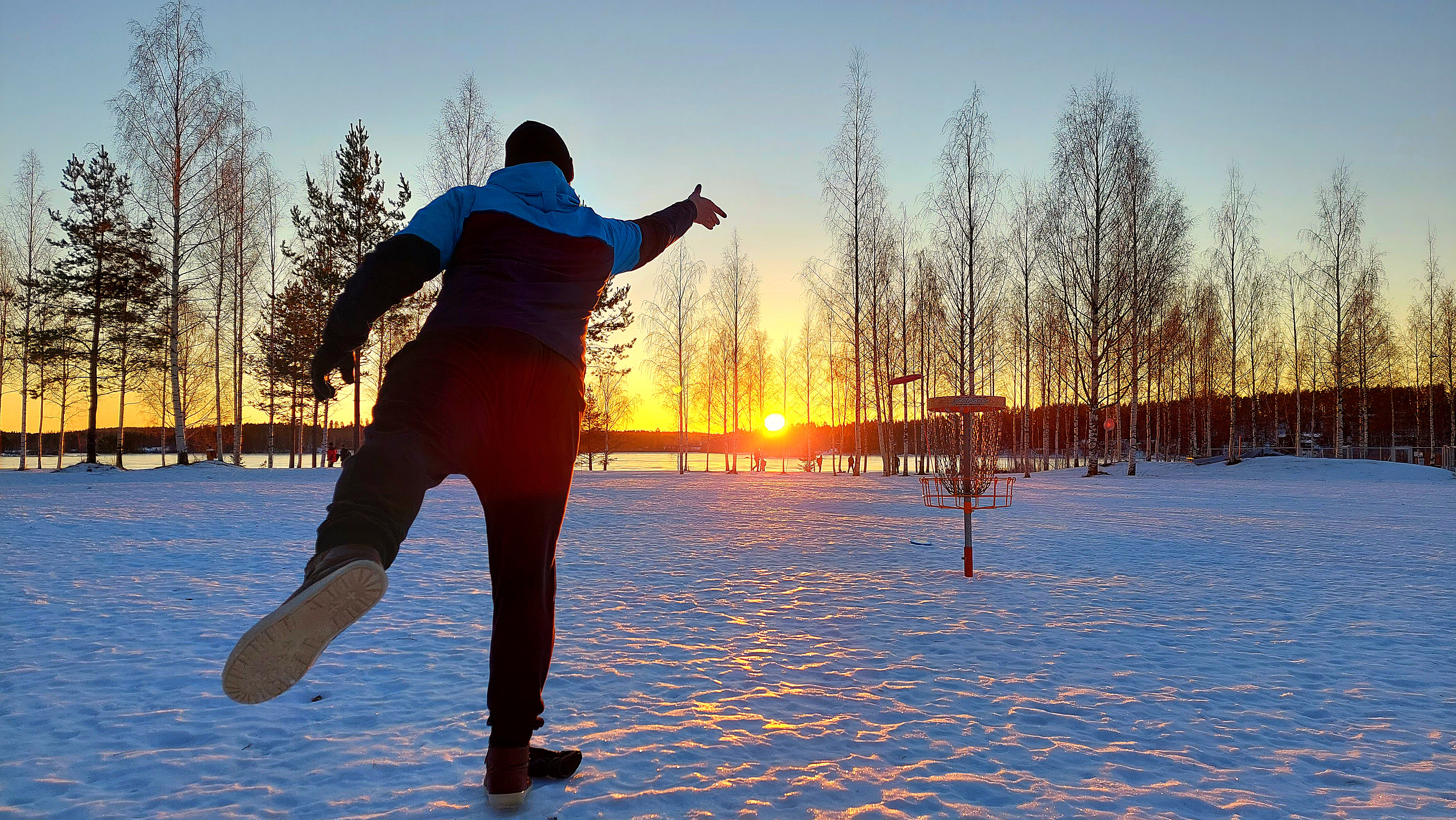 A person playing disc golf in winter.
