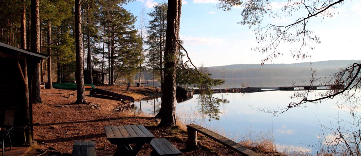 Lakeside scenery: a calm lake with a rowing boat at the shore.