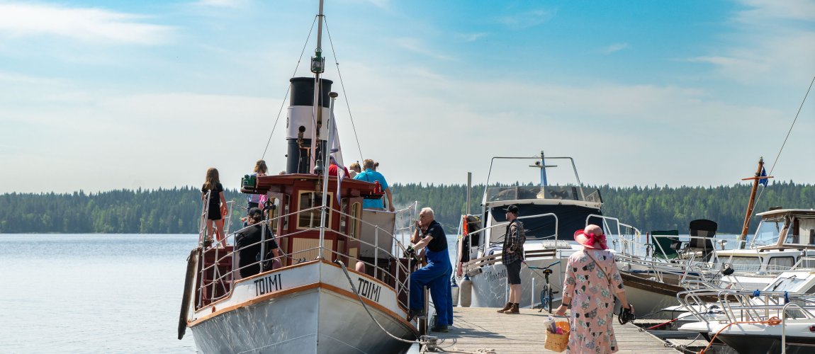 Toimi ship at the dock and people boarding it.