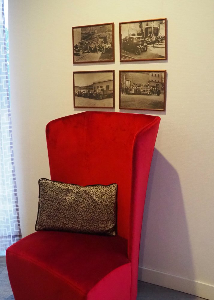 Photo of a red armchair and paintings on the walls.